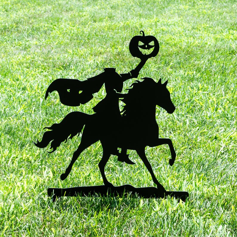 May include: Black metal silhouette of the Headless Horseman riding a horse, holding a jack-o'-lantern. The artwork is set against a backdrop of green grass, evoking a Halloween theme. The horse is in mid-stride.