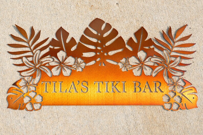 Puede incluir: Un letrero de metal con tem&aacute;tica tropical. El letrero es naranja y presenta un dise&ntilde;o recortado de hojas de palma, flores y el texto "TILA'S TIKI BAR".