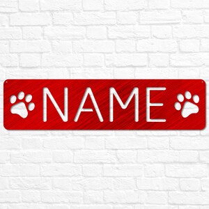 May include: Red metal sign with white paw prints on either side and the word "NAME" in white lettering.