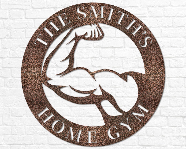 K&ouml;nnte beinhalten: Ein kupferfarbenes Metallschild mit einer wei&szlig;en Silhouette eines sich anstrengenden Bizepses. Das Schild tr&auml;gt die Aufschrift "The Smith's Home Gym" in wei&szlig;en Buchstaben.