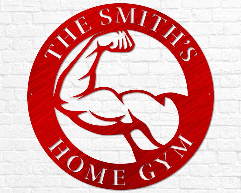 K&ouml;nnte beinhalten: Rundes Schild aus rotem Metall mit wei&szlig;em Text "The Smith's Home Gym" und einer wei&szlig;en Silhouette eines sich anspannenden Bizepses im Kreis.
