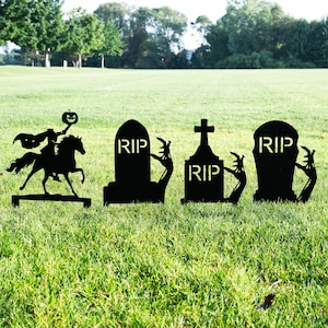 May include: Black metal Halloween yard decorations. Includes a silhouette of the Headless Horseman riding a horse, and three tombstones with "RIP" text. The tombstones have zombie hands reaching out. Perfect for Halloween.