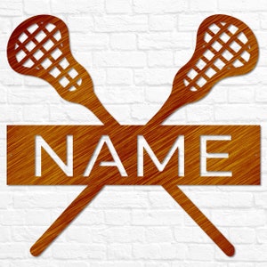 May include: A metal lacrosse stick wall decor with a wooden nameplate. The sticks are crossed and the nameplate is in the center. The nameplate is brown with white lettering. The sticks are orange.
