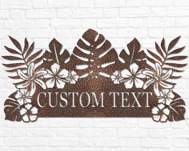 Puede incluir: Un letrero de metal con tem&aacute;tica tropical que presenta una gran hoja de monstera, flores de hibisco y hojas de palma. El letrero tiene un espacio para texto personalizado, que dice "CUSTOM TEXT".