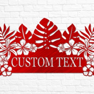 Puede incluir: Un letrero de metal rojo con un tema tropical. El letrero presenta un dise&ntilde;o grande, rojo y frondoso con flores blancas de hibisco y el texto "CUSTOM TEXT".