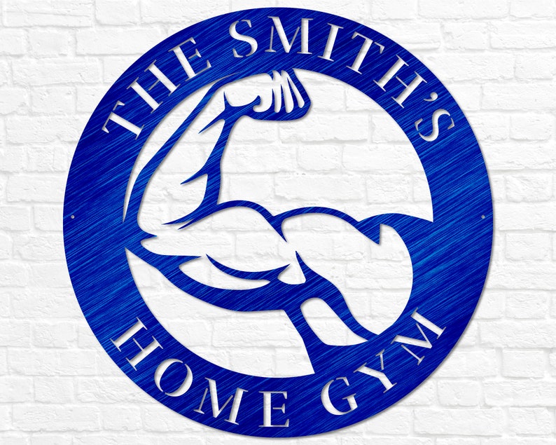 K&ouml;nnte beinhalten: Ein blaues rundes Schild aus Metall mit dem Text "THE SMITH'S HOME GYM" in wei&szlig;en Buchstaben. Im Zentrum des Kreises befindet sich eine wei&szlig;e Silhouette eines Bizepses.