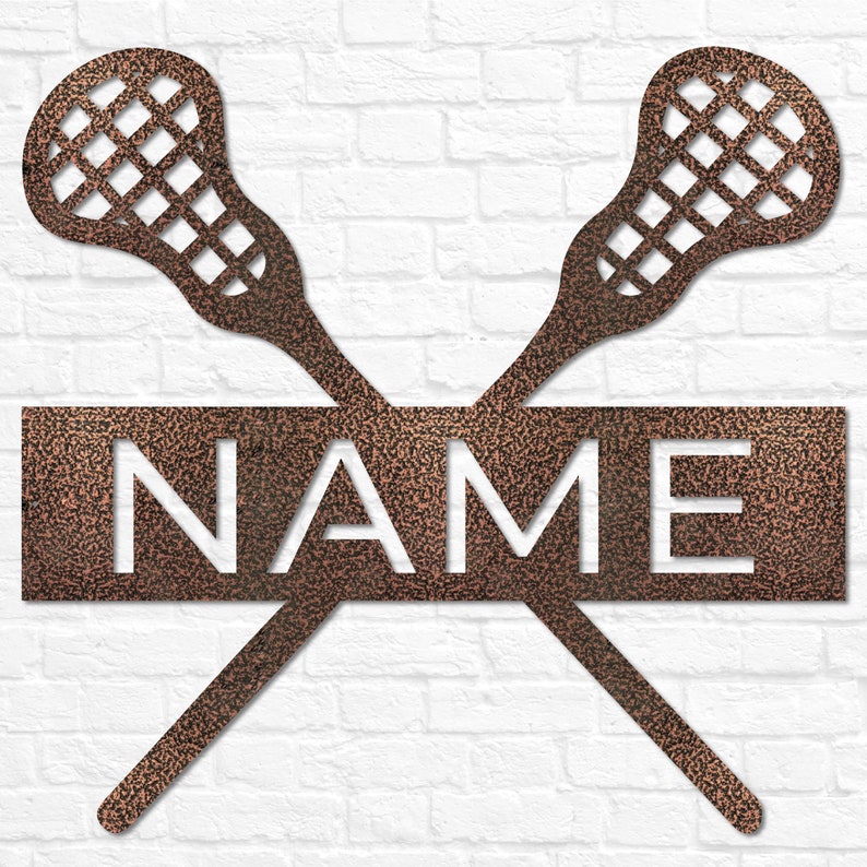 May include: A metal wall decor featuring two crossed lacrosse sticks with a rectangular sign that says "NAME". The sign and sticks are a copper color.