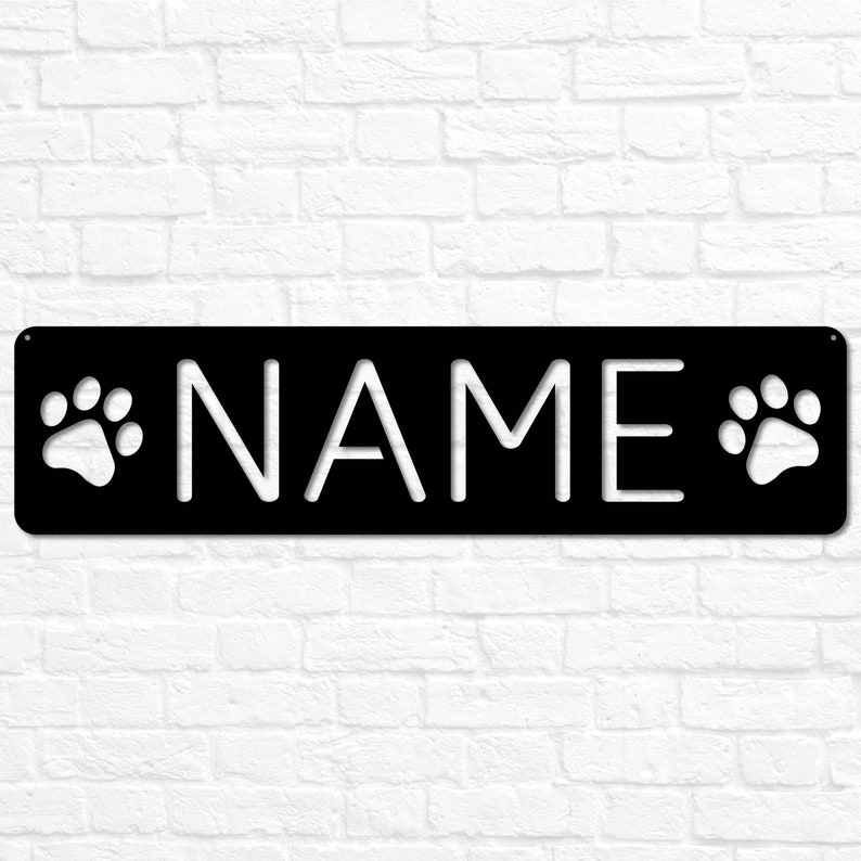 May include: Black metal sign with white paw prints on either side of the word "NAME".