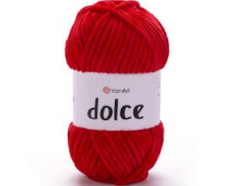 May include: A ball of bright red velvet-style yarn with a thick, plush texture. A white paper label wraps around the center, featuring the YarnArt logo and the word dolce printed in a bold, black, lowercase sans-serif font on the front.