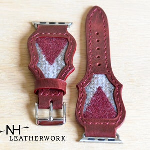 May include: Burgundy leather watch band with a geometric design. The band features a gray and burgundy felt inlay. The watch band has a silver buckle and hardware. The brand "NH Leatherwork" is printed on the bottom left.