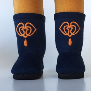 Puede incluir: Un par de botas de forro polar azul oscuro con corazones bordados en naranja y un dise&ntilde;o de l&aacute;grima.