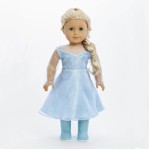 May include: A doll wearing a light blue dress with a sparkly bodice and sheer sleeves. The doll has blonde hair in a braid and is wearing light blue boots with snowflake designs.