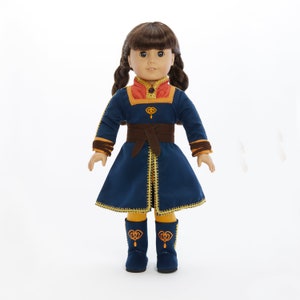 May include: A doll wearing a blue and gold dress with a brown belt and matching boots. The doll has brown hair and brown eyes.