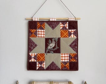 Tapiz pequeño acolchado para pared con aplique de pájaro bordado a mano.