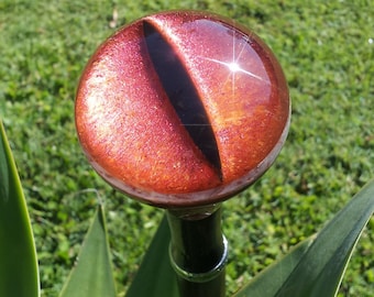 May include: A round, red, and black, metallic, decorative knob with a shiny finish.