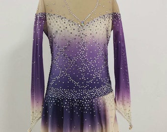 May include: A figure skating dress with a gradient design in shades of purple and beige. The long-sleeved dress is embellished with sparkling rhinestones and features a high, jeweled neckline. The skirt has a layered, ruffled hem.