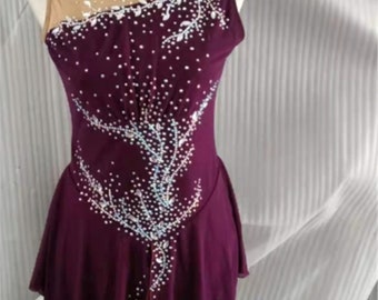 Puede incluir: Un vestido de patinaje artístico morado con un diseño floral blanco y pedrería.
