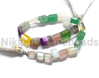 May include: A strand of colorful, faceted gemstone beads in various colors including green, purple, yellow, and pink. The beads are strung together with a white tassel at each end. The beads are rectangular in shape.