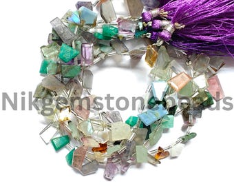 May include: A strand of colorful gemstone beads in various shapes and sizes. The beads are a mix of green, purple, blue, and clear, with a purple tassel at the end. The text "Nikgemstonebeads" is visible.