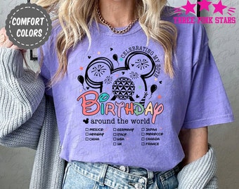 May include: Purple t-shirt with a colorful graphic of Mickey Mouse ears with a fireworks display and a globe. The text "Celebrating My 30th Birthday around the world" is below the graphic. A list of countries is below the text.