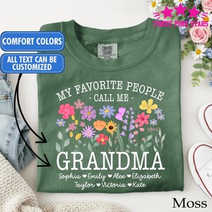 Może przedstawiać: Zielona koszulka w kolorze mchu z napisem "My Favorite People Call Me Grandma" i kwiatowym wzorem. Poniżej wymienione są imiona: Sophia, Emily, Alex, Elizabeth, Taylor, Victoria i Kate. Koszulka ma napis "Comfort Colors" i "All text can be customized".