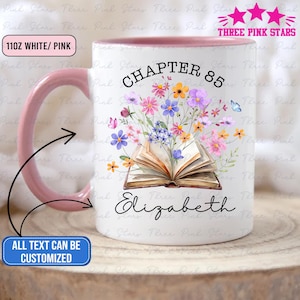 Op de afbeelding: Witte en roze keramische mok met een roze handvat en rand. De mok heeft een bloemenontwerp met een open boek, de tekst "CHAPTER 85" en de naam "Elizabeth". De mok bevat ongeveer 325 ml vloeistof.