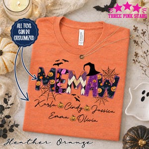 Könnte beinhalten: Ein orangefarbenes, meliertes T-Shirt mit dem Wort MEMAW in großen, gemusterten Buchstaben, verziert mit Kürbissen, Fledermäusen und Spinnennetzen. Unter dem Text stehen die Namen Karla, Cindy, Jassica, Emma und Olivia mit kleinen Kürbis-Symbolen.