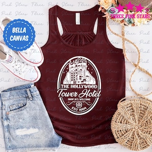 Peut inclure: Un débardeur marron avec un motif blanc représentant l'hôtel Hollywood Tower Hotel. Le motif comprend le texte "The Hollywood Tower Hotel", "Drop In's Welcome", et "Est. 1994".