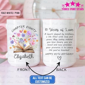 May include: White ceramic mug with a pink interior and handle. The front features the text "Chapter Eighty" above an open book with floral illustrations and the name "Elizabeth." The back reads "80 Years of Love" with a heartfelt message.