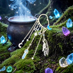 May include: A gold-colored ear cuff with celestial charms, including moons, stars, and a crystal pendant. The cuff is set against a backdrop of moss, crystals, and a bubbling cauldron, creating a mystical aesthetic.