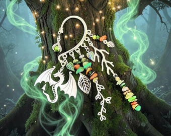 May include: Silver ear cuff featuring a dragon design, leaves, and colorful gemstones. The cuff wraps around the ear and is adorned with a variety of decorative elements. The design includes a dragon, leaves, and a branch-like structure.