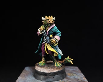 May include: A hand-painted miniature figurine of a reptilian humanoid creature with green scales, wearing a teal coat with pink cuffs, purple trousers, and a yellow sash. The figure stands on a circular base and holds a sword at its side.