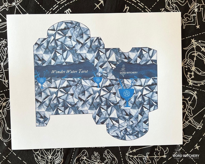 May include: A printable template for a box to hold a deck of tarot cards. The box is designed with a blue and white geometric pattern and the text "Wonder Water Tarot" and "Word Witchery".