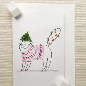 Gato juguetón con suéter festivo y gorro de árbol de Navidad: tarjeta de felicitación navideña de 4 x 6 pulgadas para desear alegría y diversión durante la temporada