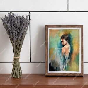 May include: A framed painting of a woman with brown hair, wearing a blue and white dress, against a yellow and green background. The painting is in a brown frame and is on a wooden surface.