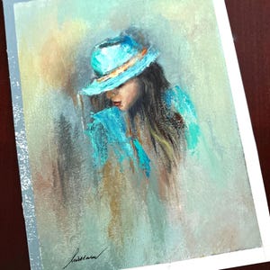 May include: A painting of a person wearing a blue hat and a blue shirt. The person is looking down and their face is partially obscured by the hat. The background is a light blue and green.