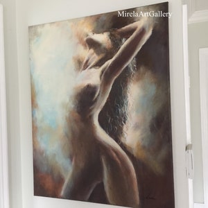 May include: A painting of a nude figure with long, flowing hair, rendered in shades of brown, beige, and blue. The figure is posed with arms raised above their head, creating a sense of movement and energy. The background is a soft, abstract wash of color.