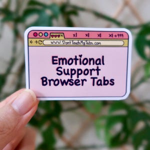Può includere: Un adesivo rosa e bianco con un design di finestra del browser. Il testo sull'adesivo recita "Emotional Support Browser Tabs" e "www.DontTouchMyTabs.com".