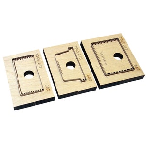 Op de afbeelding: Drie houten stansmallen met verschillende vormen. De stansmallen zijn gemarkeerd met T045 1/3, T045 2/3 en T045 3/3.