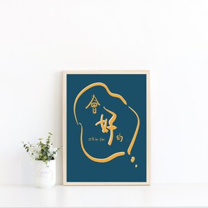 Puede incluir: Una impresión enmarcada con un fondo azul verdoso y un contorno dorado de un globo de diálogo que contiene caracteres chinos y el texto "Todo estará bien".