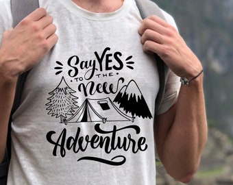 Könnte beinhalten: Cremefarbenes T-Shirt mit dem schwarzen Text "Say YES to the New Adventure". Das Design zeigt ein Zelt, Bäume und Berge. Die Person trägt eine schwarze Kappe und einen Rucksack.
