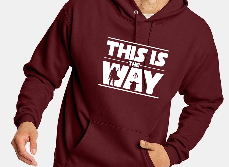 Puede incluir: Sudadera con capucha burdeos con un gr&aacute;fico blanco que dice "THIS IS THE WAY" con siluetas de un personaje y una criatura. La sudadera tiene una capucha con cord&oacute;n y un bolsillo delantero.