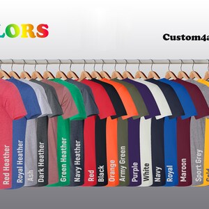 May include: A display of various colored t-shirts hanging on wooden hangers. The shirts are in a variety of colors, including red, blue, green, black, and orange. The word "COLORS" is at the top left, and "Custom4alldesign" is at the top right.