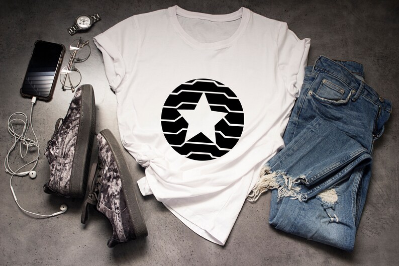Puede incluir: Camiseta blanca con un dise&ntilde;o de estrella negra dentro de un c&iacute;rculo, combinada con vaqueros azules y zapatillas estampadas. Un reloj, gafas y un smartphone con auriculares completan el conjunto informal.
