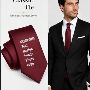 Könnte beinhalten: Eine einfarbige dunkelrote Krawatte mit dem weißen Text CUSTOM Text Design Image Photo Logo. Die Krawatte ist gefaltet und getragen mit einem weißen Hemd, einem schwarzen Sakko und einem weißen Einstecktuch abgebildet. Der Text Classic Tie Timeless Formal Style ist sichtbar.