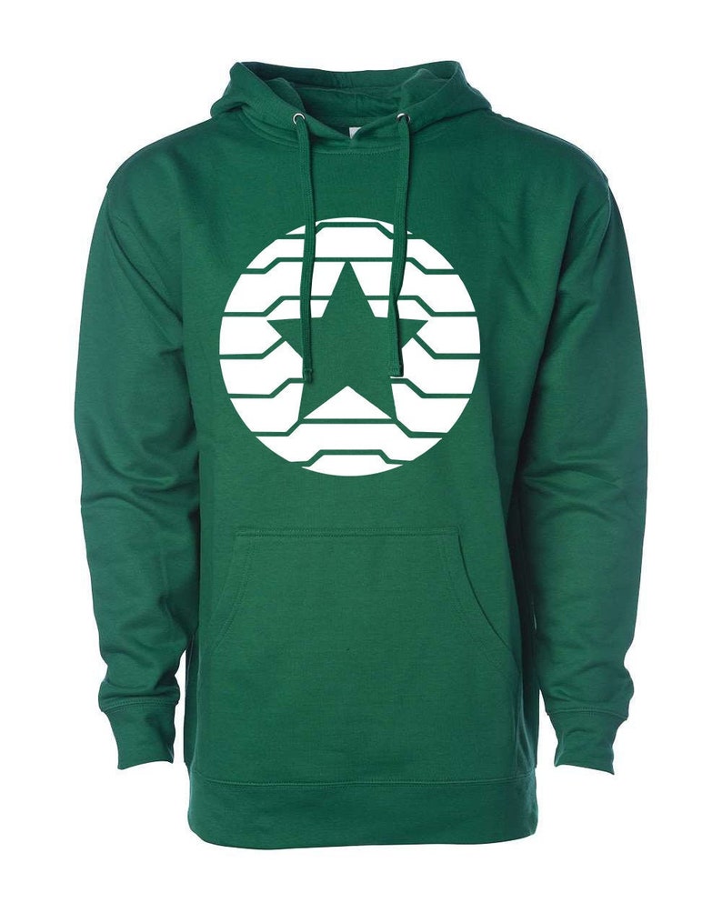 K&ouml;nnte beinhalten: Ein gr&uuml;ner Kapuzenpullover mit einem wei&szlig;en Stern-Design in einem kreisf&ouml;rmigen Muster. Der Pullover hat eine Vordertasche und eine Kapuze mit Kordelzug. Das Design ist auf der Brust zentriert.