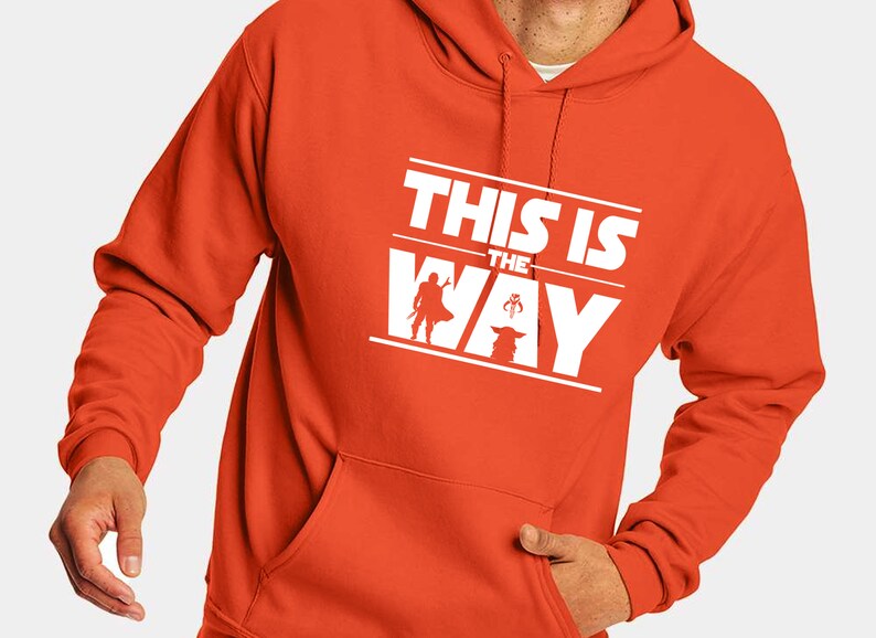 Puede incluir: Sudadera con capucha naranja con un gr&aacute;fico blanco que dice "THIS IS THE WAY" con siluetas de un Mandaloriano y Grogu. La sudadera tiene un bolsillo delantero y una capucha con cord&oacute;n.