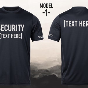 Könnte beinhalten: Marineblaues Sicherheits-T-Shirt mit dem Text "SECURITY [TEXT HERE]" auf der Vorder- und Rückseite. Das Wort "SECURITY" ist auch auf den Ärmeln aufgedruckt. Das T-Shirt ist Modell -1-.