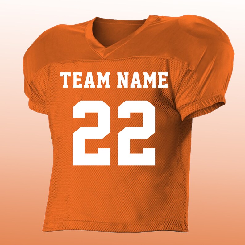 Peut inclure: Maillot de football am&eacute;ricain orange avec lettrage et chiffres blancs. Le maillot affiche le texte "TEAM NAME" au-dessus du num&eacute;ro "22". Il poss&egrave;de un col en V et des &eacute;paules rembourr&eacute;es.