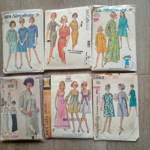May include: A collection of vintage sewing patterns featuring illustrations of women's dresses and coats. The patterns are from brands like Simplicity and McCall's, with text including pattern numbers and prices. The color palette includes shades of blue, green, and pink.